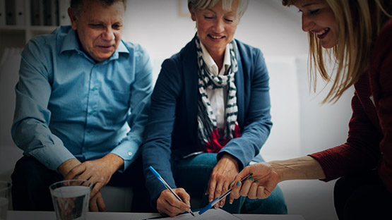 Old couple signing documents with an expert claims advisor